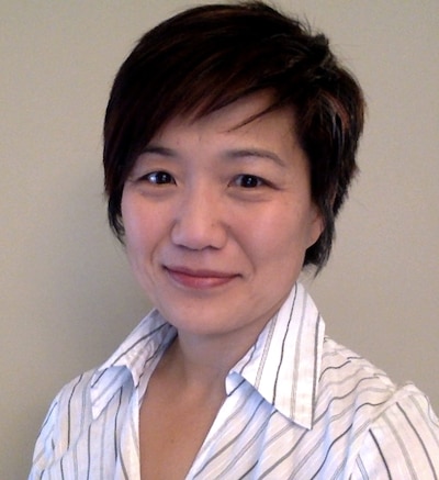 A portrait of a woman in a striped collared blouse.