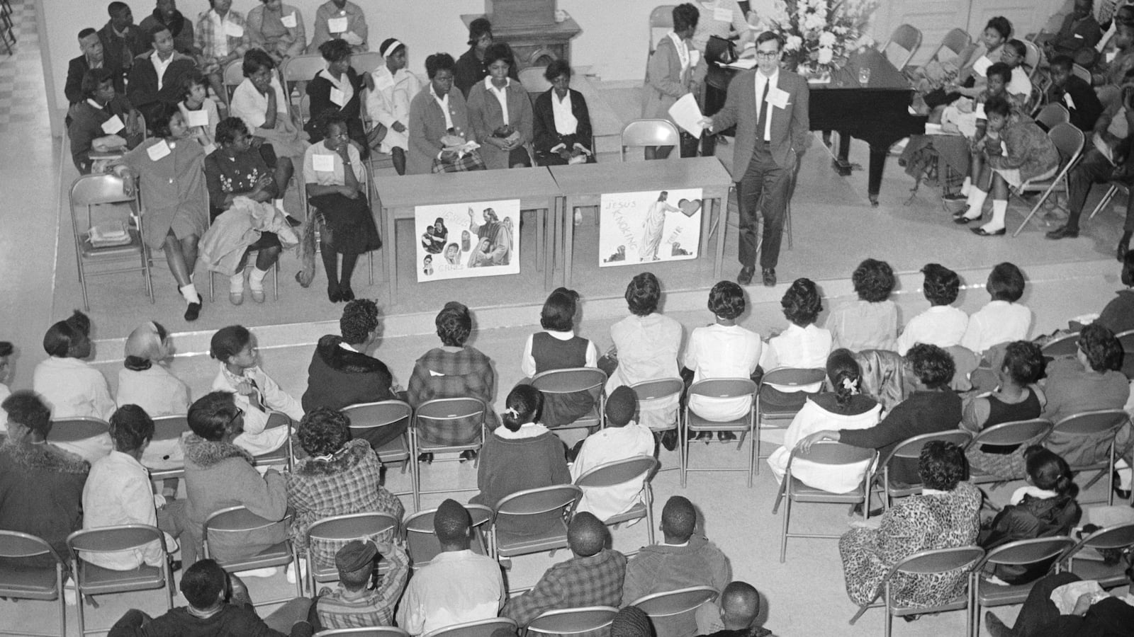 A group of students and teachers gather in a church that is being used as a makeshift school.