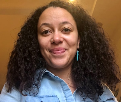 Headshot of a woman wearing a nose ring and a denim shirt.