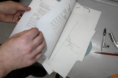 A pair of hands opens up a worksheet about the science of the solar eclipse.